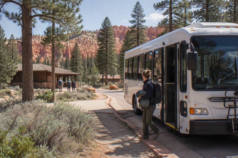 Shuttle bus at a Bryce Canyon stop with pine forest behind