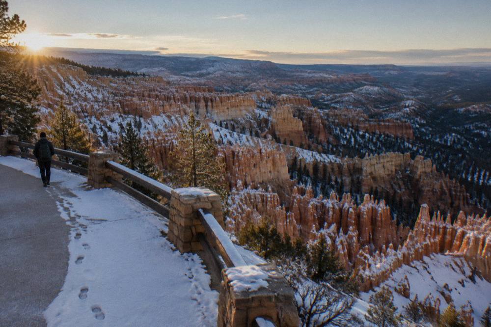 Sunlight raking across hoodoo formations in the Bryce Amphitheater with a dusting of snow on the canyon floor