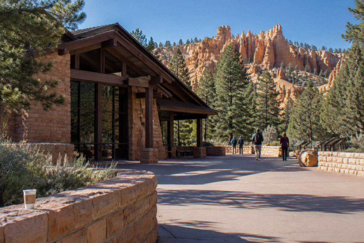 Sunlit orange hoodoo formations rising from the Bryce Canyon amphitheater under a pale blue sky
