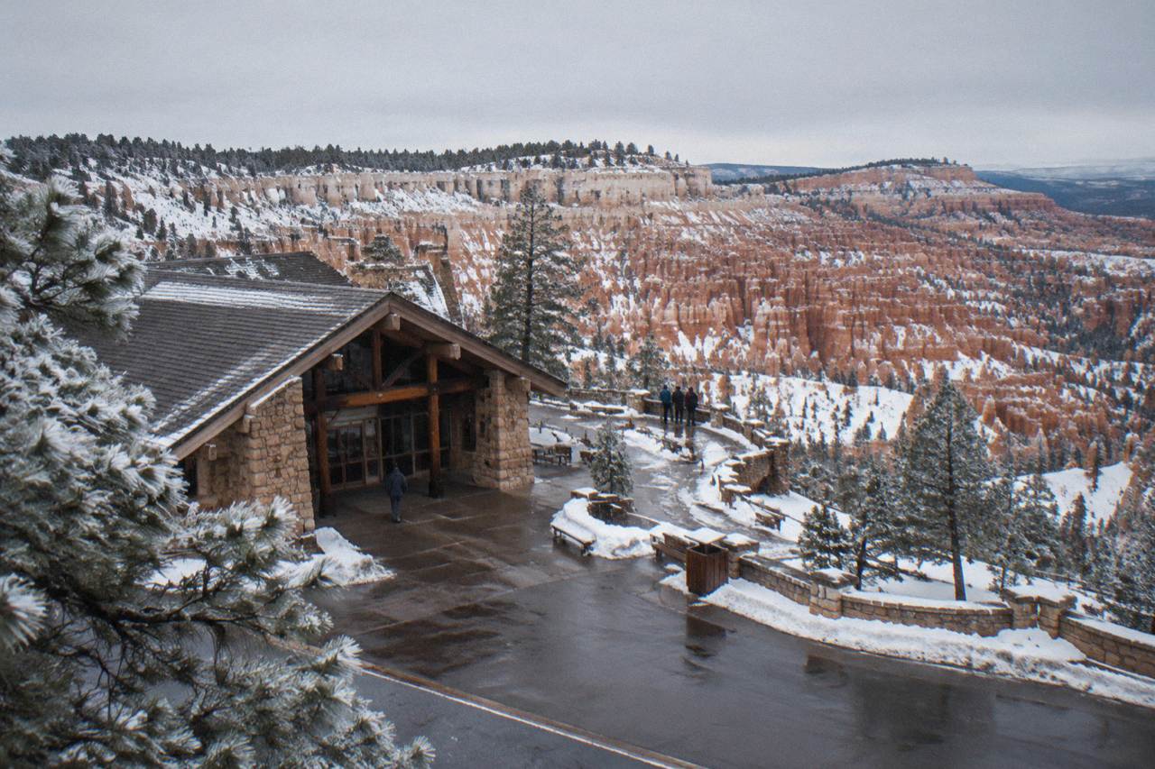 Red rock hoodoo amphitheater under a winter sky with snow patches on the canyon rim