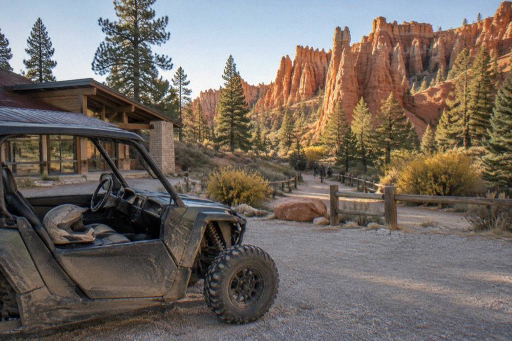 Parked side-by-side vehicle at a trailhead beside red rock formations