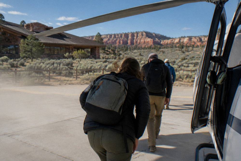 Passengers boarding a helicopter on a sunny high desert morning