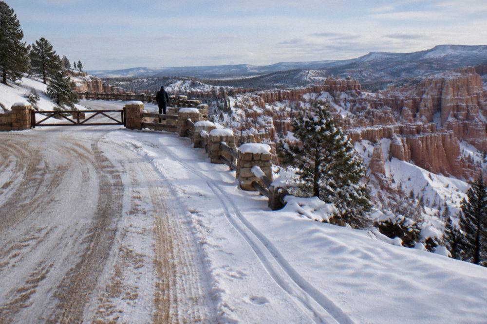 Snow-dusted hoodoos and a quiet plowed road at Bryce Canyon in winter