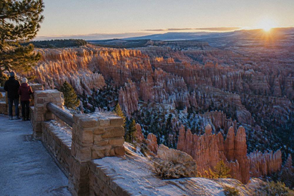 First light striking hoodoo spires across the Bryce Amphitheater from a rim overlook
