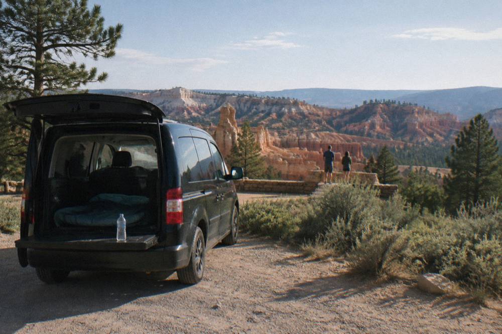 A small passenger van parked at a desert viewpoint overlook