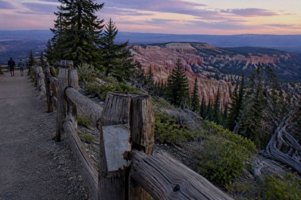 Weathered wooden fence posts along a high plateau trail at dusk