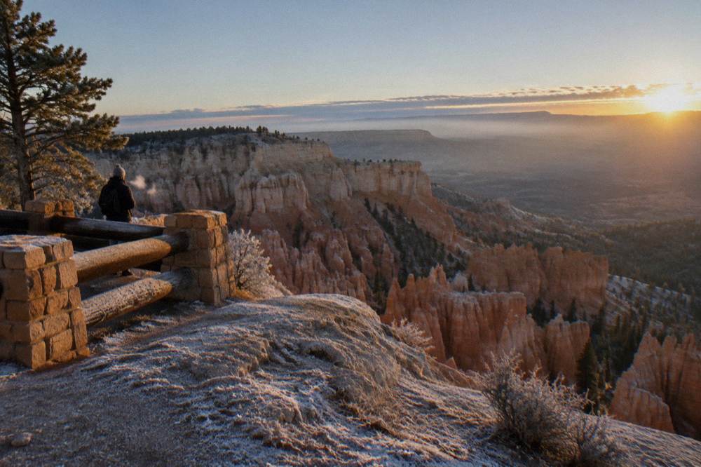 A high plateau edge with layered canyon rock descending into morning haze