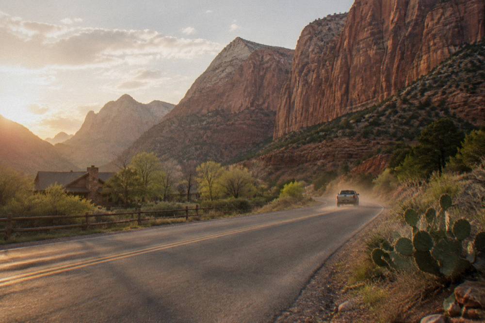 A highway curving toward tall red cliffs in southern Utah canyon country