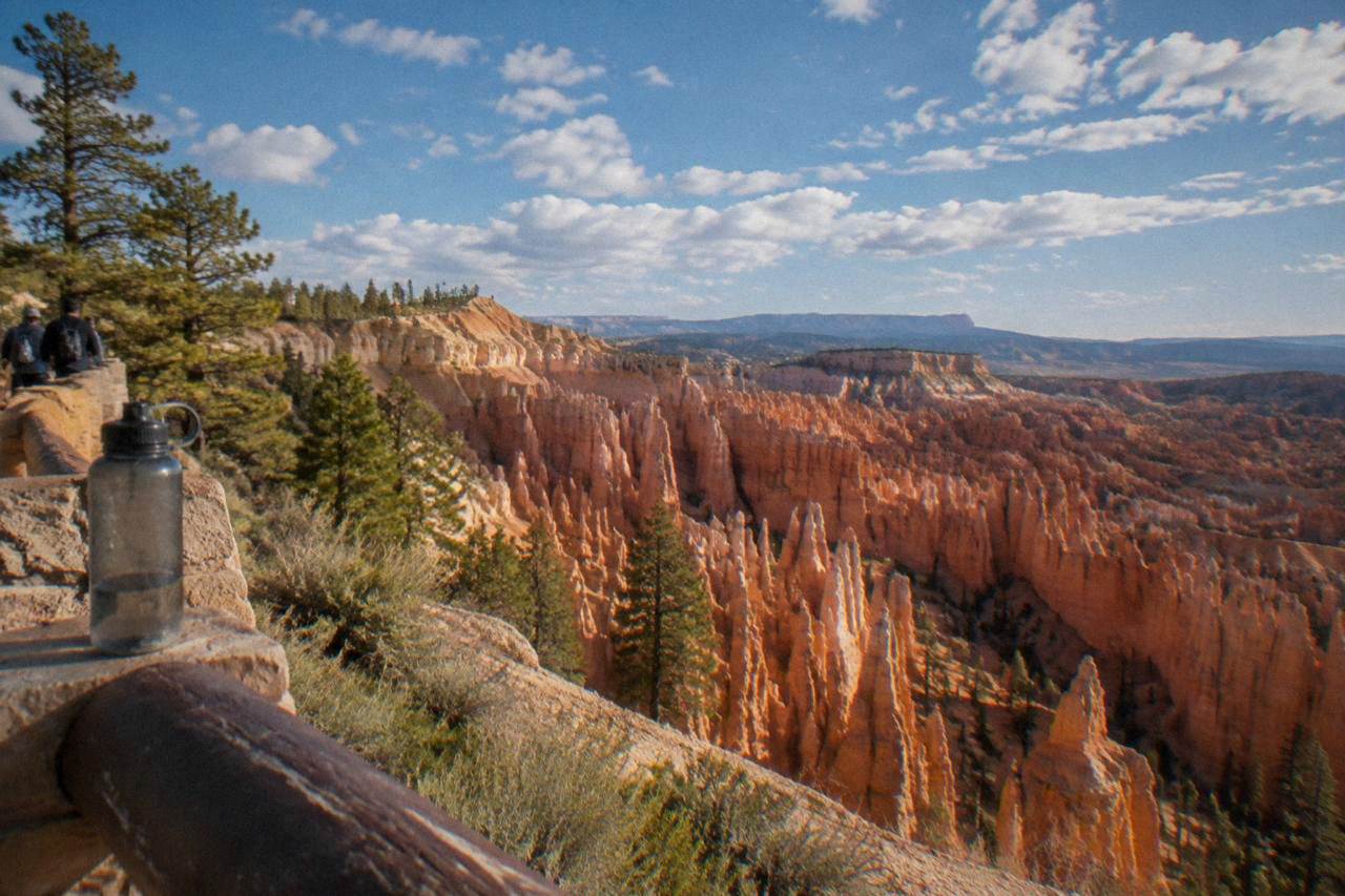 Red rock hoodoos of the Bryce Amphitheater under a wide sky with scattered clouds