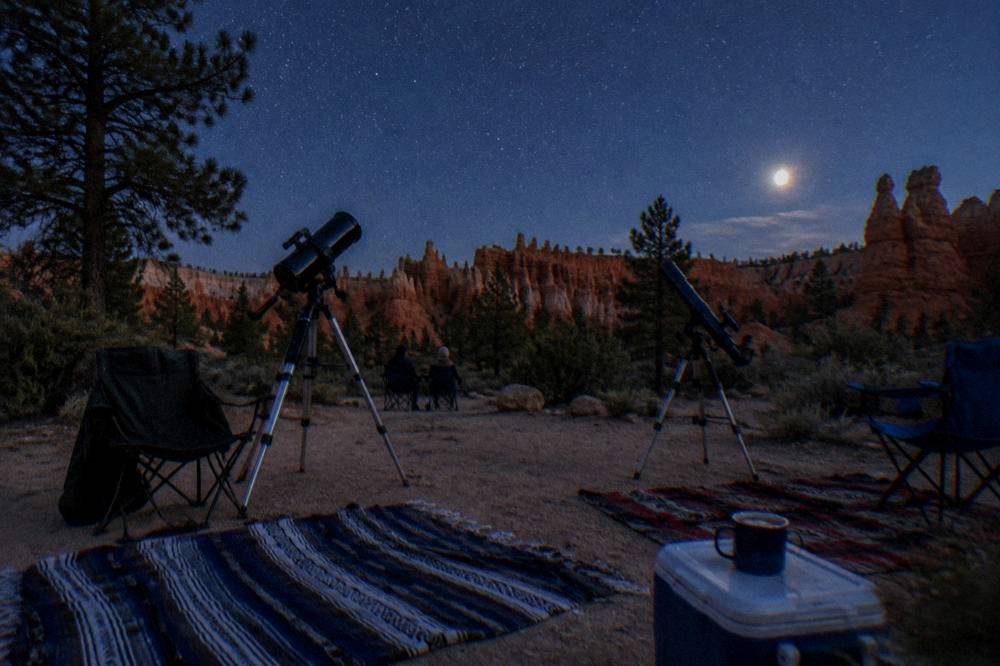 Telescopes and chairs set out under a star filled desert night sky