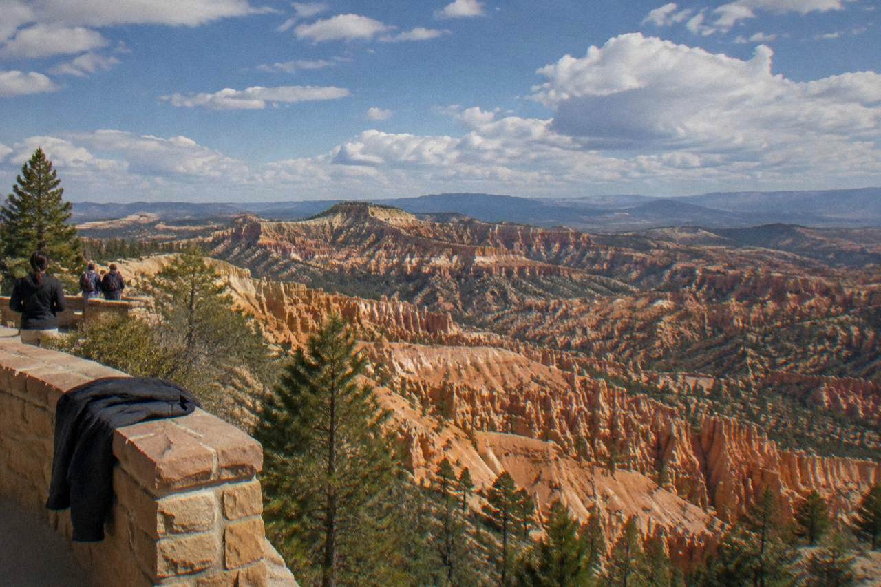 Sunlit hoodoo formations of the Bryce Amphitheater beneath a wide afternoon sky