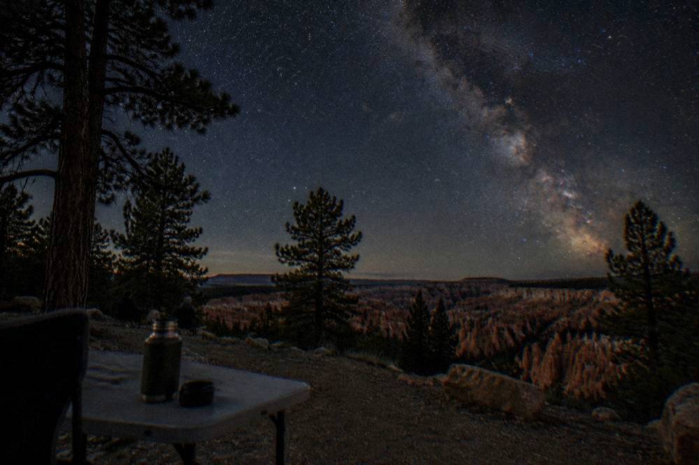 Night sky filled with stars above dark canyon silhouettes